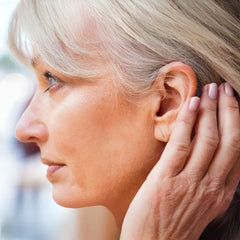 Ceretone Beacon behind the ear over the counter hearing aid worn in an outdoor setting, discreet and small.