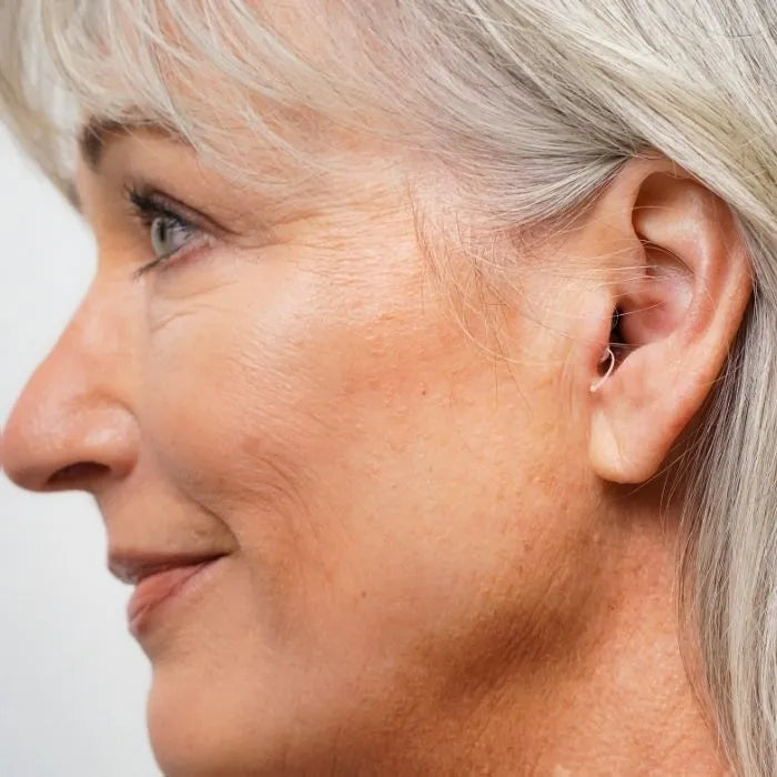 In ear look of the Ceretone Core One OTC hearing aid , female ear.