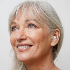 Side profile view of style over the counter hearing aids on woman. 